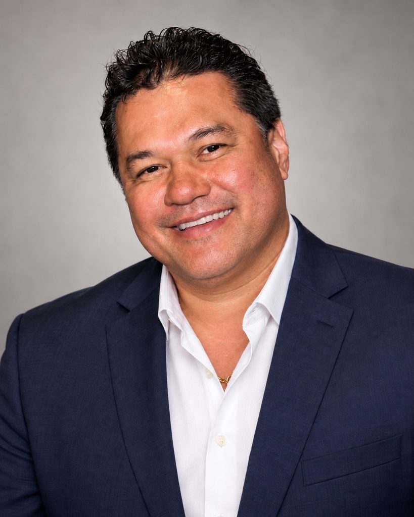 Kalani Souza, sales and leadership consultant, wearing a navy suit.